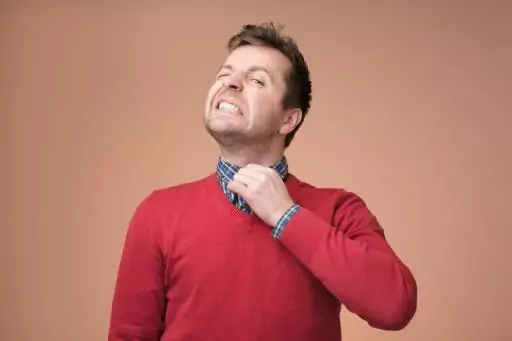Man in red shirt looking uncomfortable