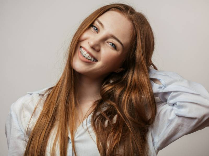 Smiling young red head with clear braces in Broomfield, CO